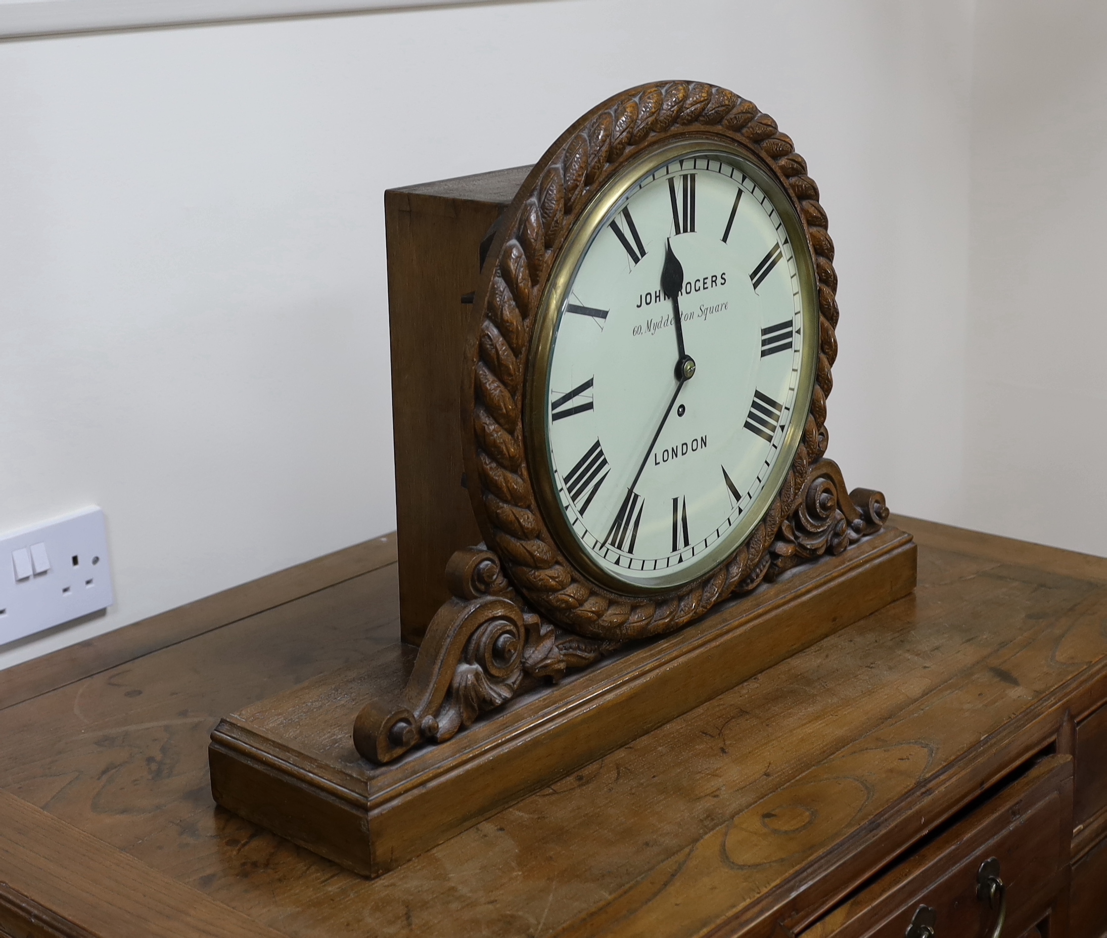 A Victorian carved oak mantel timepiece with fusee movement, signed John Rogers of London, 62cm wide